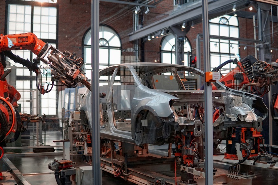 Bras robotisés assemblant une caisse de voiture sur une ligne